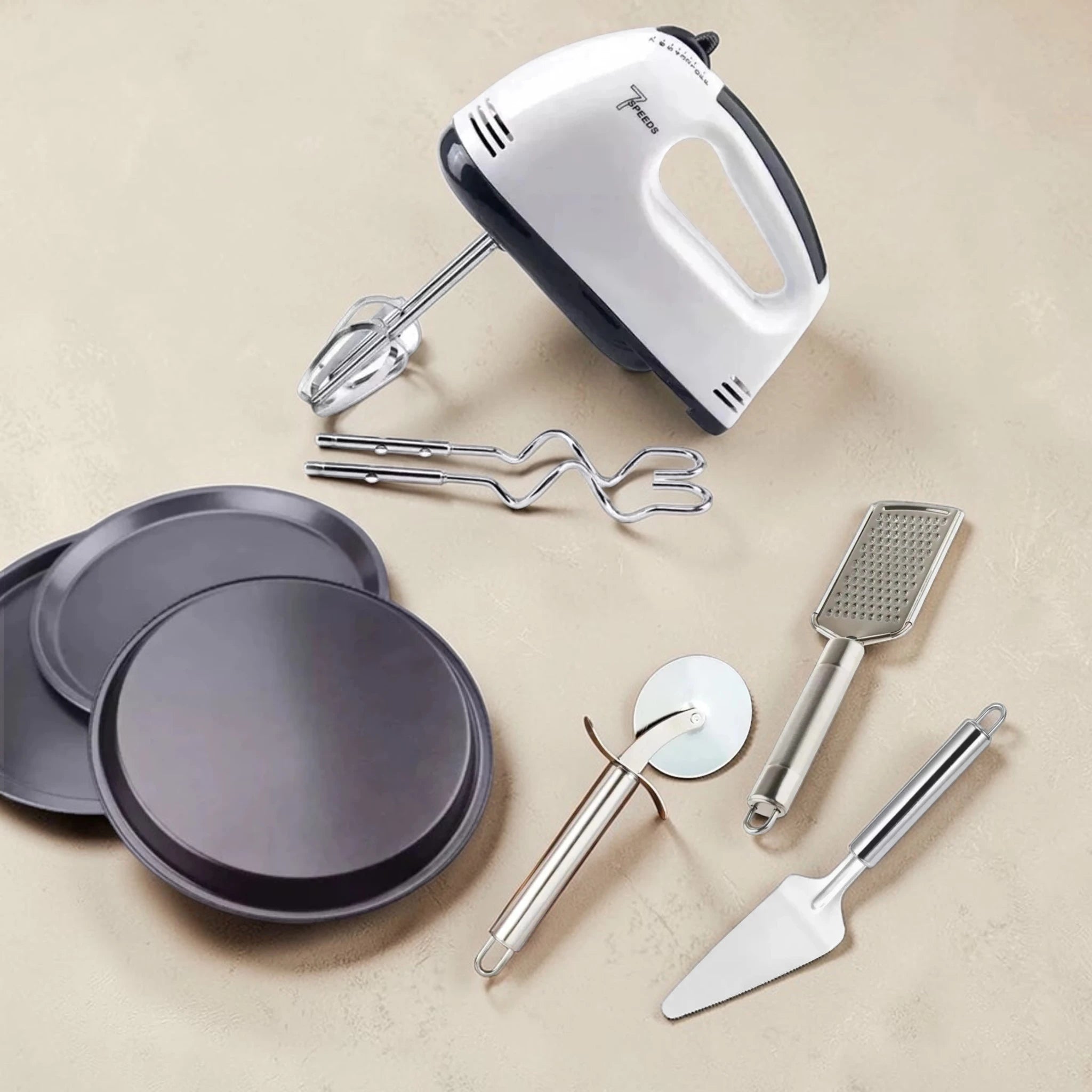 Kitchen tools including a hand mixer, plates, a grater, and a spatula on a beige background