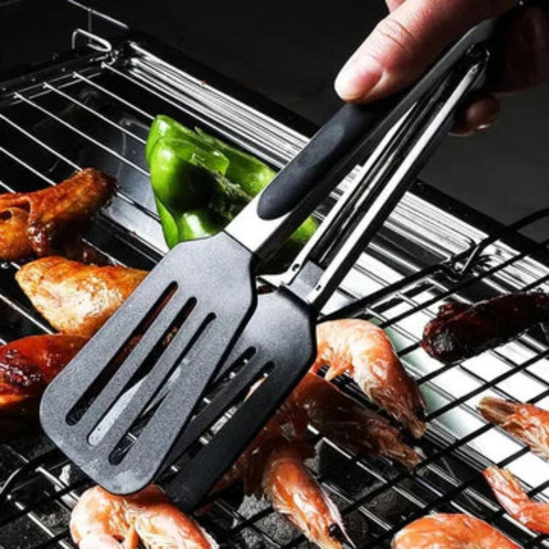 Black slotted spatula on a grill with food
